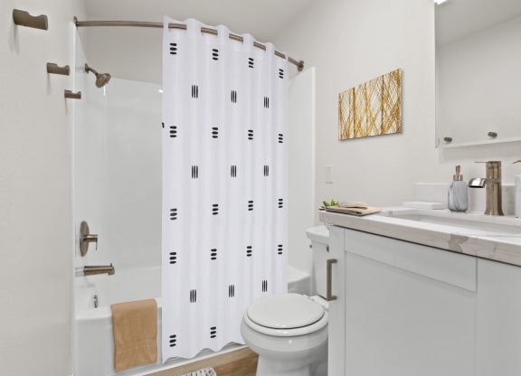 Bathroom with a white sink and toilet and a shower with a shower curtain  at Harvard Manor, Irvine, CA