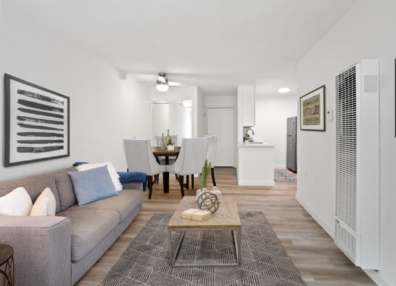 Living room and dining room with white walls and wood floors at Harvard Manor, Irvine, 92612