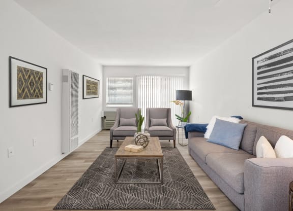 Living room with a gray couch and two gray chairs at Harvard Manor, Irvine, CA