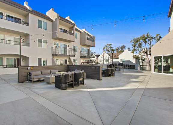 A sunny day at a modern apartment complex with a patio area.