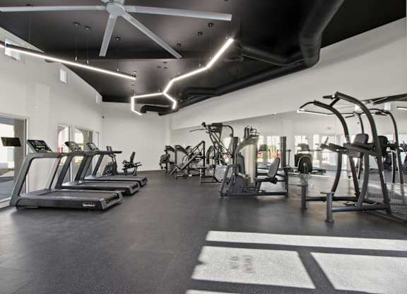 A gym with treadmills, elliptical machines, and other exercise equipment.