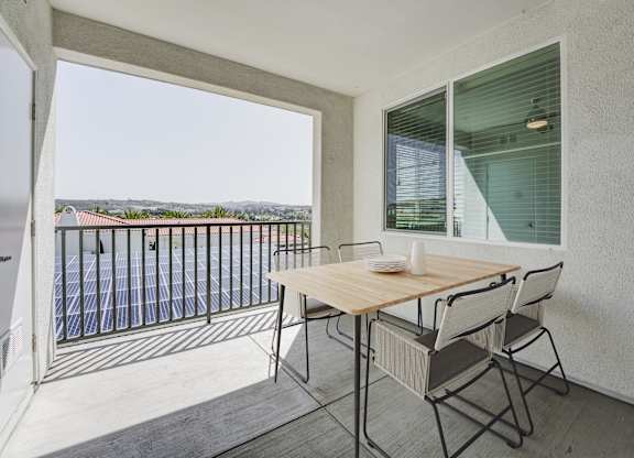 A balcony with a table and chairs overlooking a pool at Montecito at Carlsbad, Carlsbad, CA 92010
