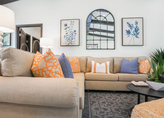 a living room with a tan couch and blue and orange pillows at Arroyo Villa Apartments, California, 91320