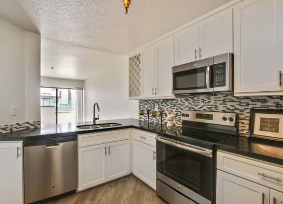a kitchen with a stove top oven next to a sink  at Masselin Park West, California, 90036