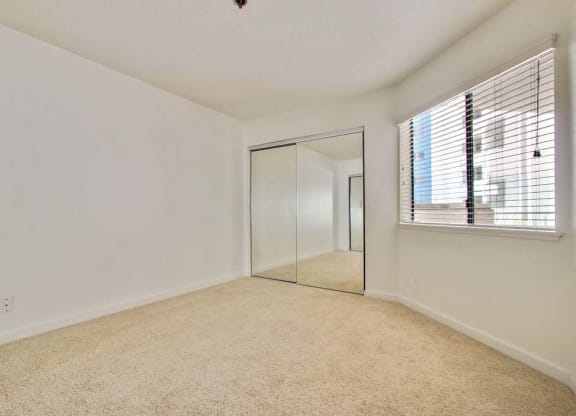 a bedroom with a mirror and a window  at Masselin Park West, Los Angeles, CA