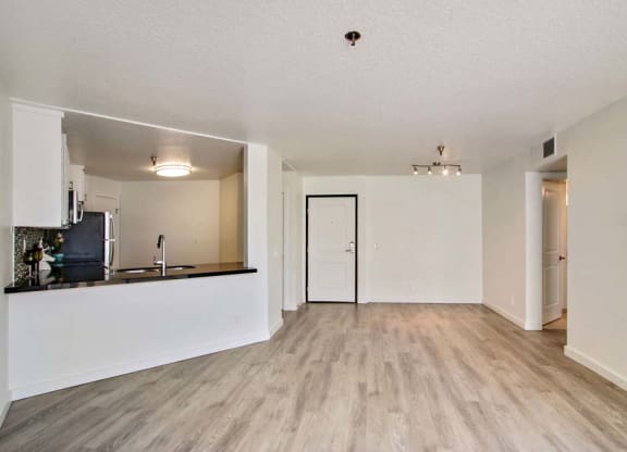 an empty living room with a kitchen in the background  at Masselin Park West, California
