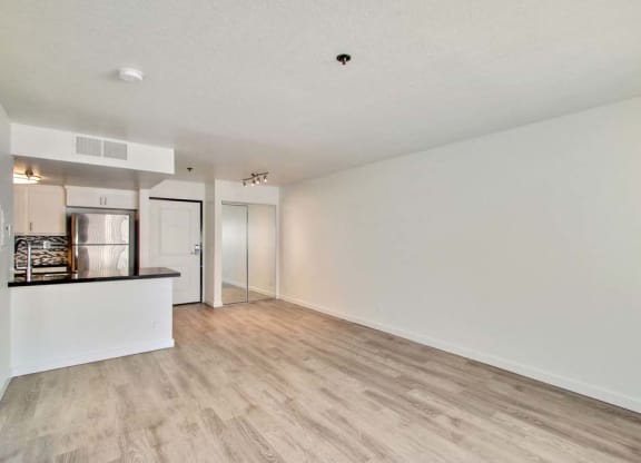 an empty living room with a kitchen in the background  at Masselin Park West, Los Angeles, California