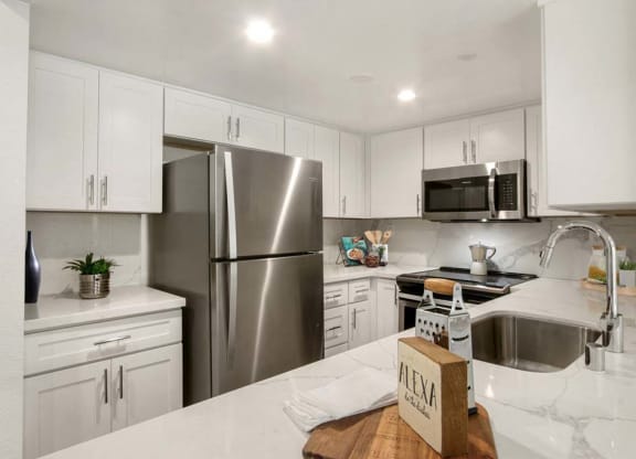 a kitchen with a refrigerator freezer next to a sink  at Masselin Park West, Los Angeles