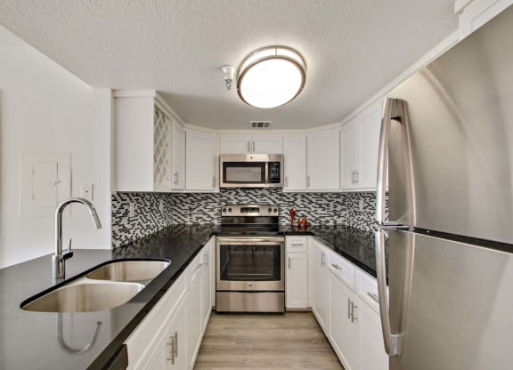 a kitchen with a sink and a refrigerator  at Masselin Park West, California