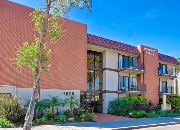 a large brick building with a tree in front of it  at Sherway Villa, Reseda