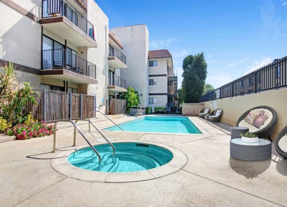 a swimming pool with a hot tub in front of an apartment building  at Sherway Villa, Reseda, 91335