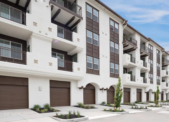 a white and brown apartment building with brown garage doors at Deer Creek Apartments, San Ramon, 94582
