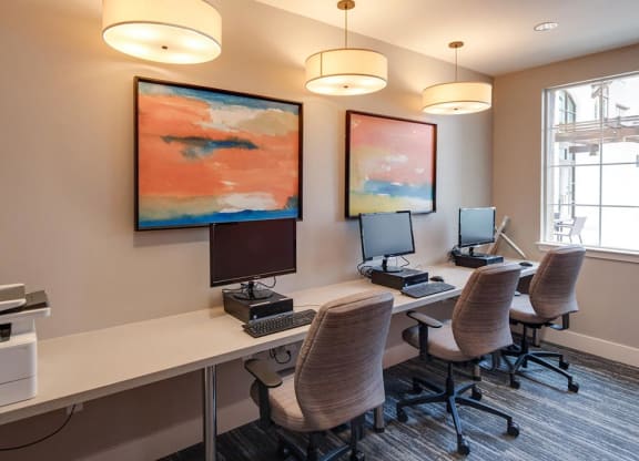 a computer lab with three computers and three chairs  at Deer Creek Apartments, San Ramon, CA, 94582