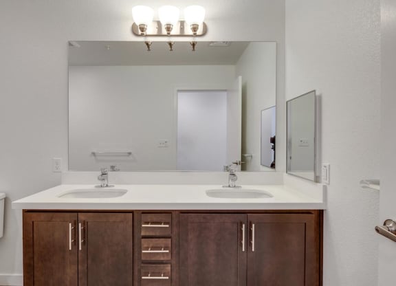 a bathroom with two sinks and a mirror with vanity lights at Deer Creek Apartments, San Ramon, 94582