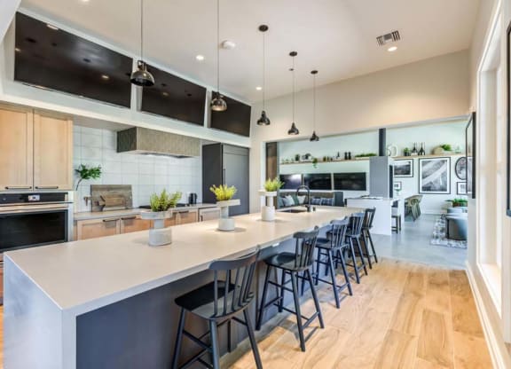 a kitchen with a long counter and chairs at The Vineyards Apartments, California, 91326