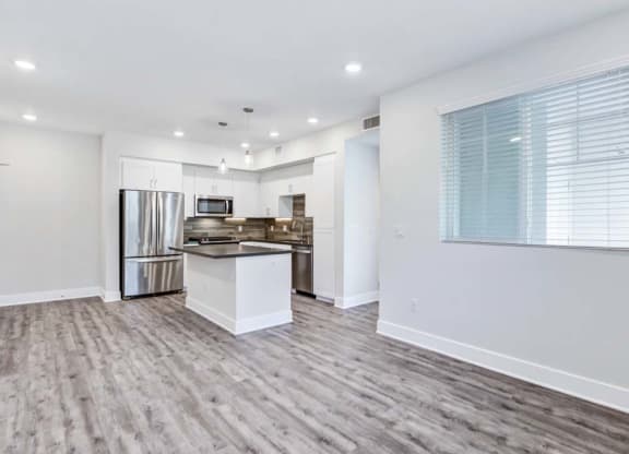 a kitchen with a stove top oven next to a refrigerator at The Vineyards Apartments, California