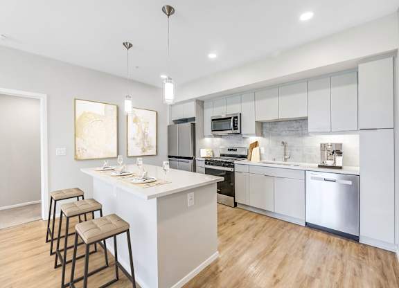 A modern kitchen with a bar area and stools.