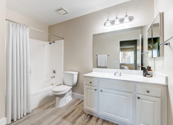 a bathroom with a shower toilet and sink at Redlands Park Apts, Redlands, CA, 92373