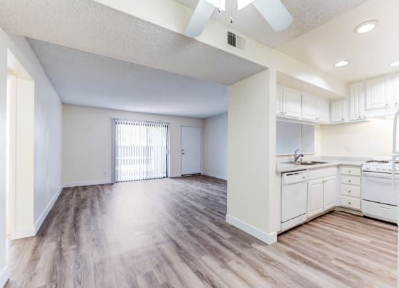 an empty kitchen and living room with a ceiling fan  at Redlands Park Apts, California, 92373