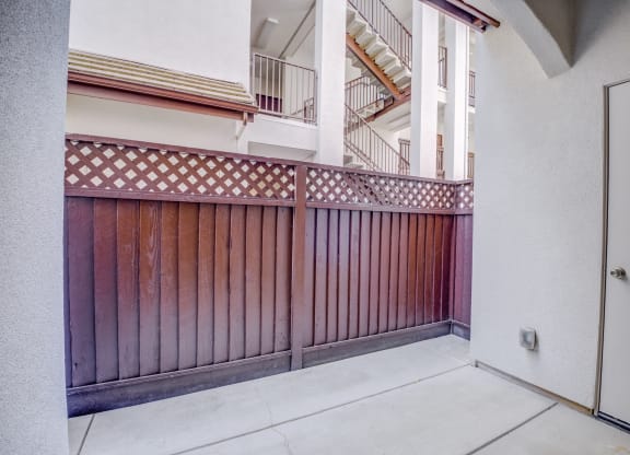 a balcony with a wooden fence and a white building with a staircase in the background  at Seville at Gale Ranch, California