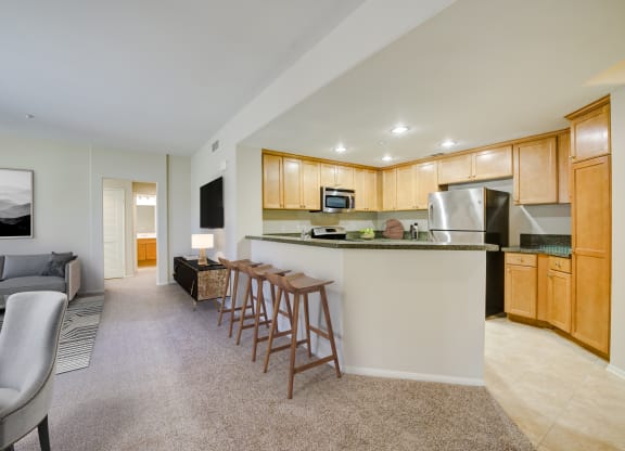 a kitchen and living room with wood cabinetry  at Sonoma at Porter Ranch, Porter Ranch, California