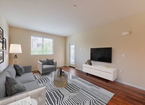 a living room with a couch and chair and a tv on the wall  at Ventana Senior Apartments, Northridge, CA, 91326