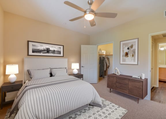 a bedroom with a large bed, ceiling fan, and walk-in closet at Ventana Senior Apartments, Northridge, CA