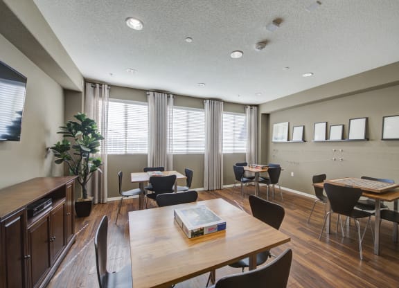 a common area with tables and chairs and a television  at Ventana Senior Apartments, Northridge, CA