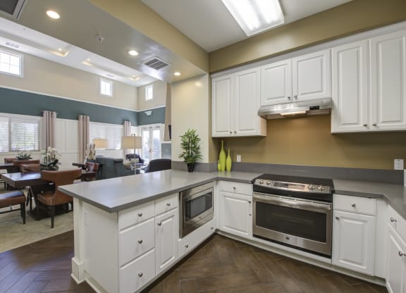 a kitchen with white cabinets and stainless steel appliances  at Ventana Senior Apartments, California, 91326