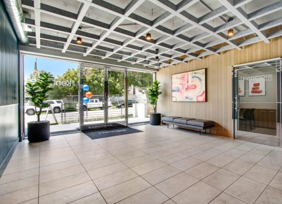 a lobby with a glass door and a glass wall with a view of the street at The Kenmore Los Feliz, Los Angeles, CA