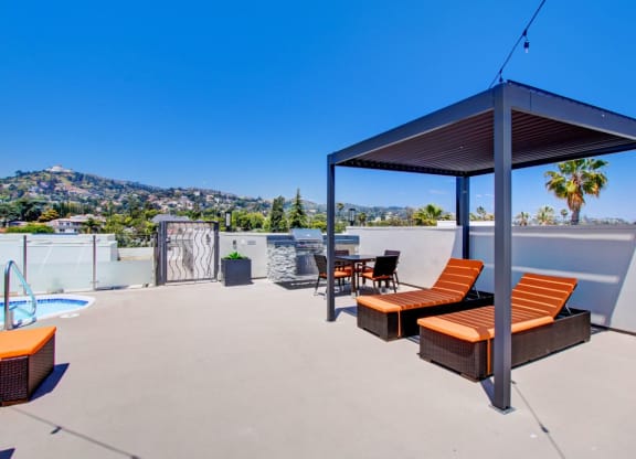 a rooftop patio with a table and chairs and a pool at The Kenmore Los Feliz, Los Angeles, CA