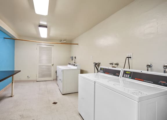 a laundry room with two washes and a dryer in it at Palm Capri Apartments, Burbank, 91501