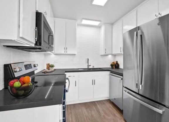a kitchen with white cabinets and stainless steel appliances at Palm Capri Apartments, Burbank, 91501