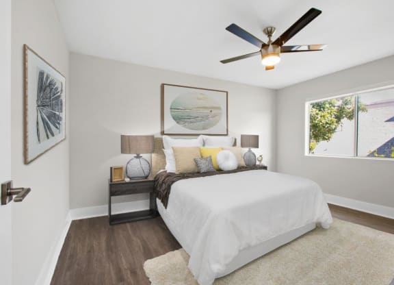 a bedroom with a large bed and a ceiling fan at Palm Capri Apartments, Burbank, CA