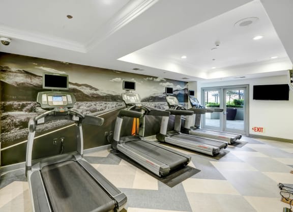 a gym with treadmills and televisions  at Apex Mission Valley, San Diego, California
