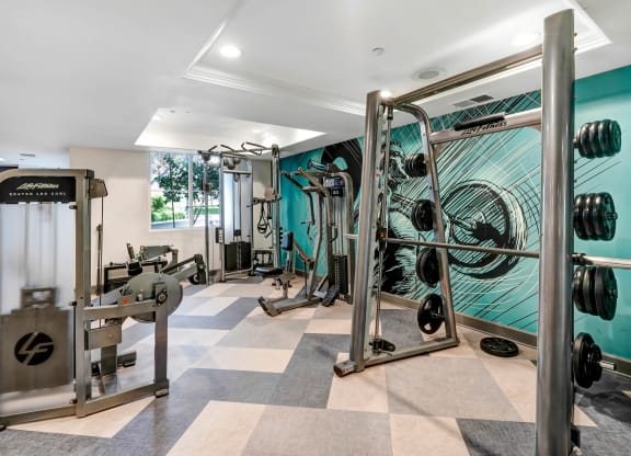 a home gym with a turquoise wall and a checkered floor  at Apex Mission Valley, San Diego, California