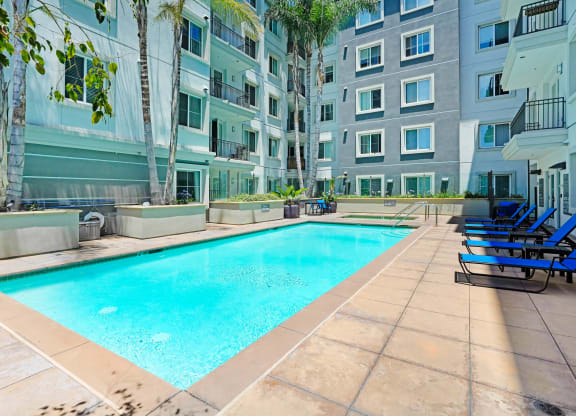 an apartment with a swimming pool in front of a building   at Apex Mission Valley, San Diego, California