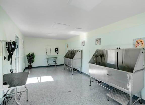 a room with two large stainless steel sinks and a table and chairs at The Park Apartments, Rancho Cucamonga, California