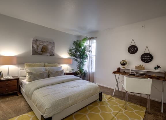 a bedroom with a bed and a desk at Bella Terra Apartments, Henderson