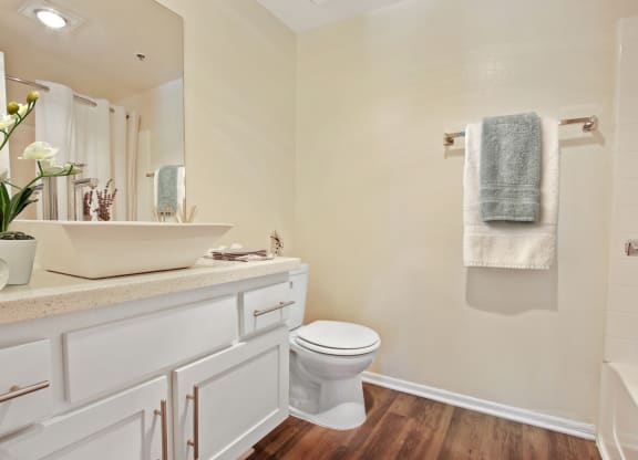 a bathroom with a toilet sink and mirror at Palm Royale Apartments, California, 90034