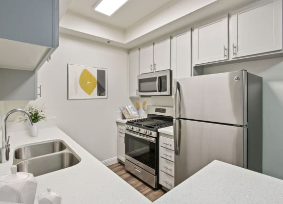 a kitchen with white cabinetry and stainless steel appliances at Palm Royale Apartments, California, 90034