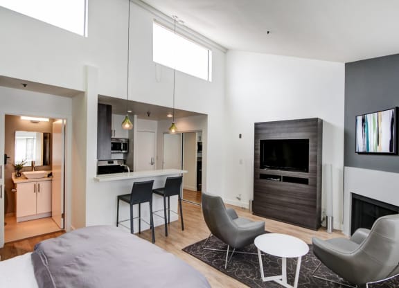 a bedroom with a bed and a chair in a room  at El Greco Lofts, Los Angeles, CA