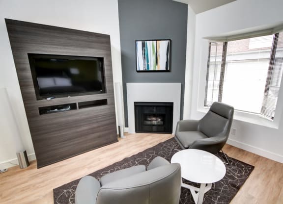 a living room with a fireplace and two chairs  at El Greco Lofts, Los Angeles, 90024