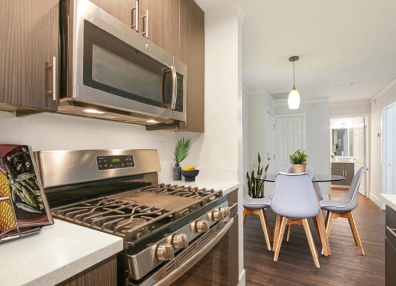 a kitchen and dining room with a stove and a microwave at Atrium, Los Angeles, CA