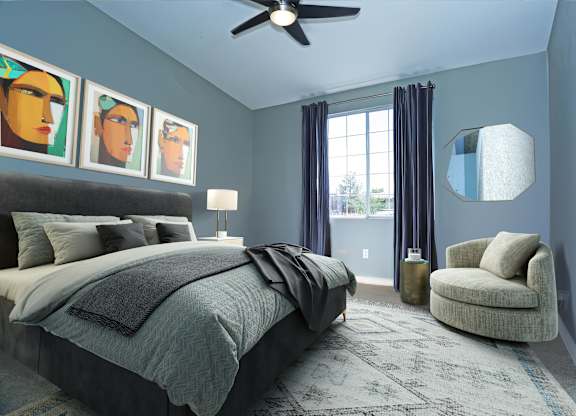 A bedroom with a bed, chair, and artwork on the wall.