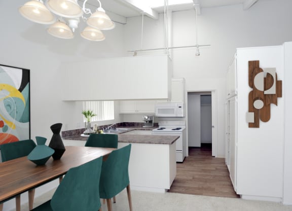 a kitchen and dining room with white cabinets and a table at The Villas at Monarch Beach, California