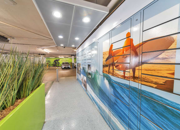 a mural of a person on a surfboard is painted on the wall of an office corridor  at The Plaza Apartments, Los Angeles, California