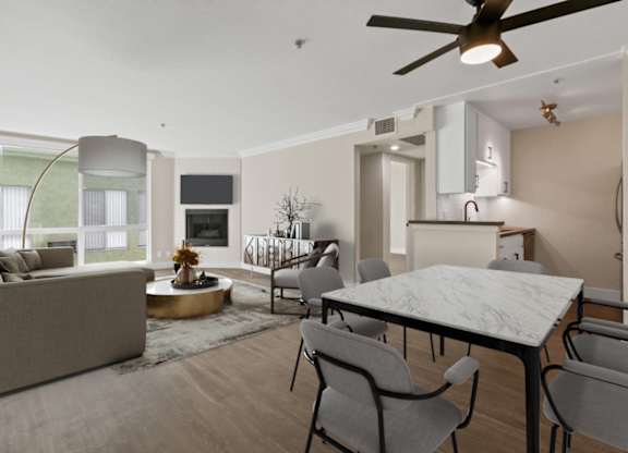 A modern living room with a grey sofa, a round coffee table, and a dining table with chairs at Rochester Apartments, California, 90024