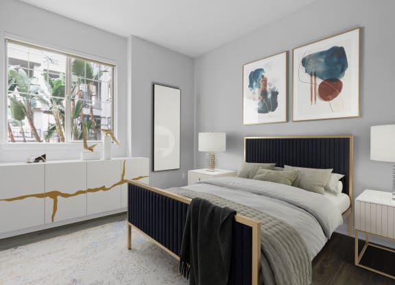 a bedroom with a bed and two paintings on the wall at The Adler Apartments, Los Angeles, CA