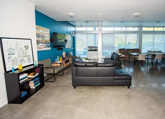 A living room with a grey couch and a bookshelf.